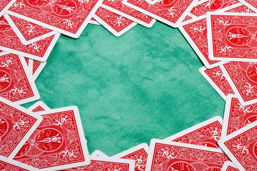 Close up view of a bunch of flipped playing cards spread on a green cloth table.