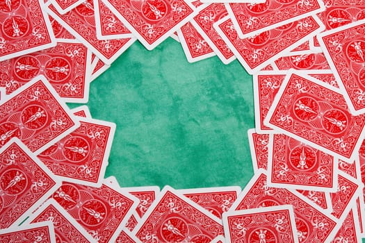 Close up view of a bunch of flipped playing cards spread on a green cloth table.