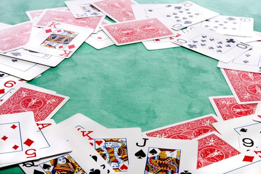 Close up view of a bunch cards spread on a green cloth table.