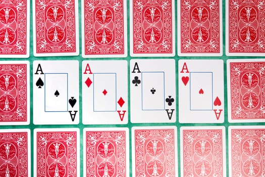 Close up view of a bunch of flipped playing cards spread on a green cloth table.