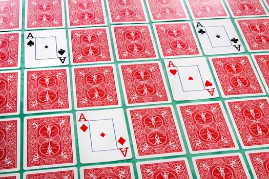 Close up view of a bunch of flipped playing cards spread on a green cloth table.