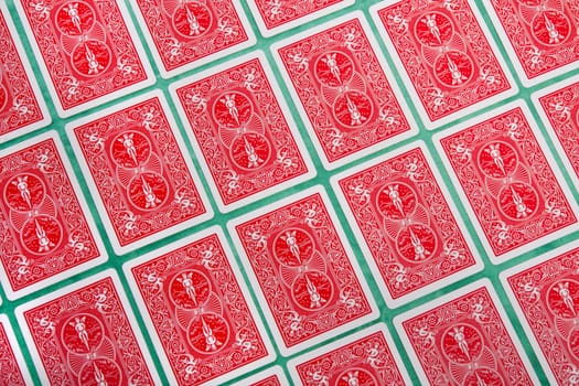 Close up view of a bunch of flipped playing cards spread on a green cloth table.