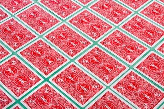 Close up view of a bunch of flipped playing cards spread on a green cloth table.