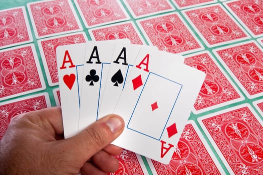 Close up view of a bunch of flipped playing cards spread on a green cloth table.