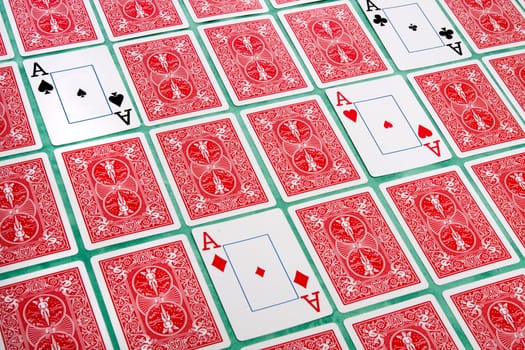 Close up view of a bunch of flipped playing cards spread on a green cloth table.