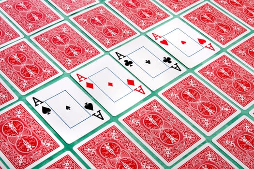 Close up view of a bunch of flipped playing cards spread on a green cloth table.