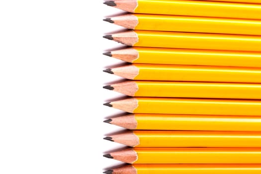 Close up view of a bunch of yellow pencils isolated on a white background.