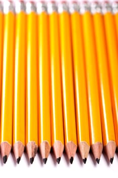 Close up view of a bunch of yellow pencils isolated on a white background.