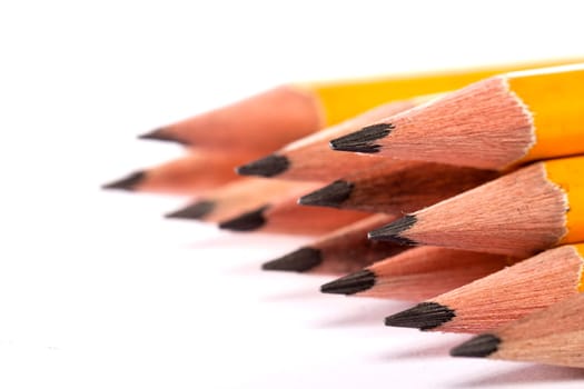 Close up view of a bunch of yellow pencils isolated on a white background.