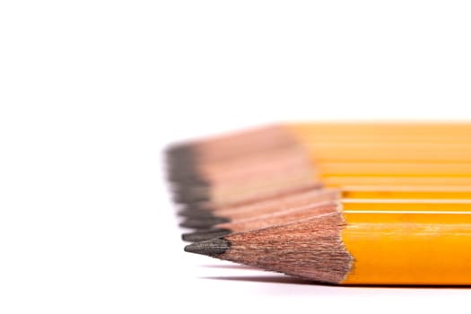Close up view of a bunch of yellow pencils isolated on a white background.
