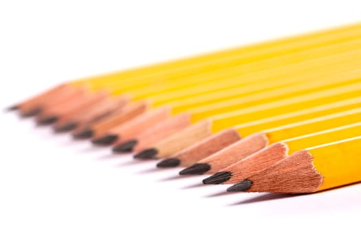 Close up view of a bunch of yellow pencils isolated on a white background.