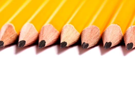 Close up view of a bunch of yellow pencils isolated on a white background.