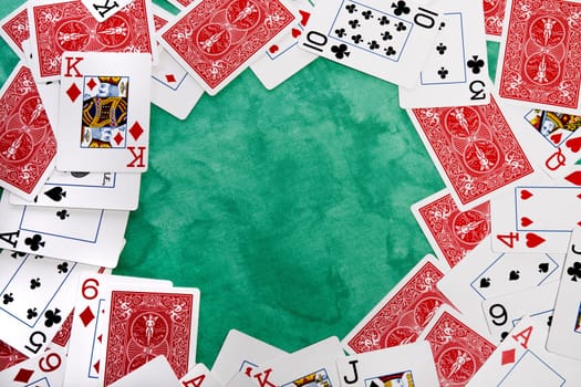 Close up view of a bunch cards spread on a green cloth table.