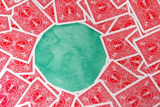 Close up view of a bunch of flipped playing cards spread on a green cloth table.