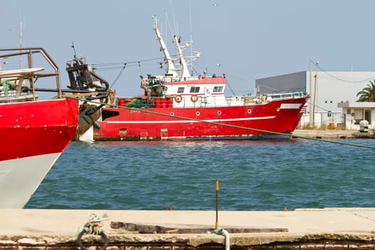 View of a red fishing boat anchored on the docks.