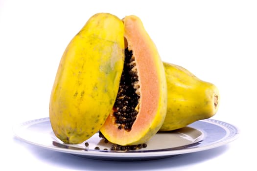 Close up view of papaya fruit sliced presented on a dish.