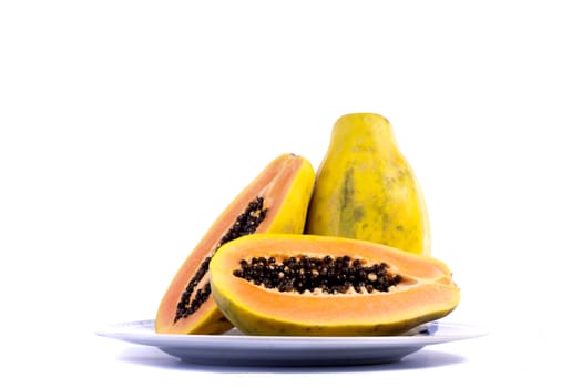 Close up view of papaya fruit sliced presented on a dish.
