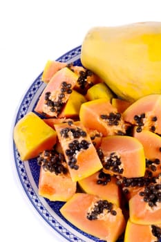 Close up view of papaya fruit sliced presented on a dish.