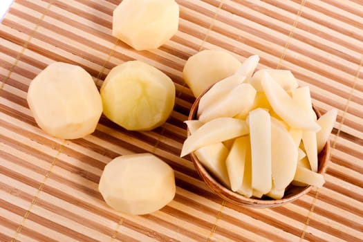 Close up view of some sliced potatoes isolated on bamboo background.