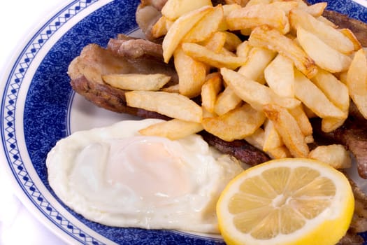 Close up view of a bunch of fried potatoes in slices, with egg and roasted meat.