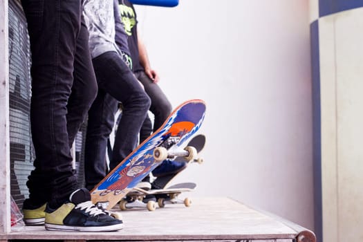 View of a bunch of skaters with skate boards on a pipe.