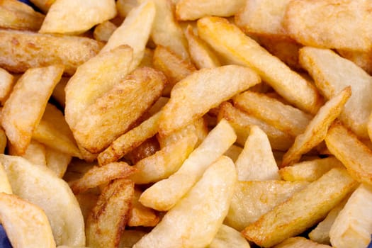 Close up view of a bunch of fried potatoes in slices.