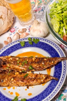 Close up view of a Portuguese meal of Wahoo grilled fish with annatto sauce and Mediterranean salad.