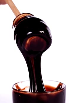 Close up view of a glass of honey and another of chocolate with cookie rolls.