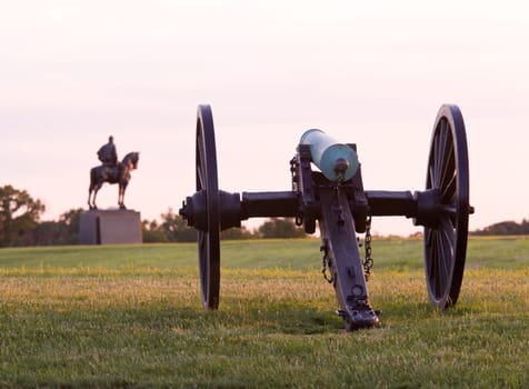Sunset view of the old cannons in a line at Manassas Civil War battlefield where the Bull Run battle was fought. Stonewall Jackson statue is in the distance. 2011 is the sesquicentennial of the battle