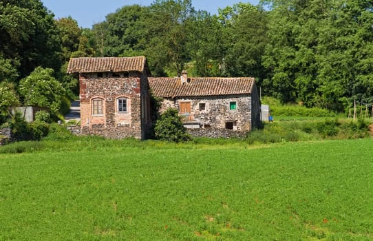 Typical Catalan countryside, rural grass with your mower, straw waltz and the church, surrounded by mountains