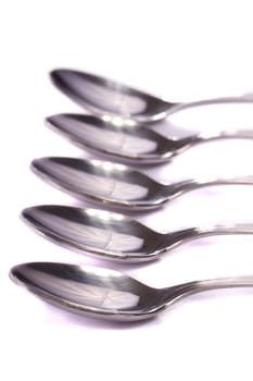 Close up view detail of some spoons isolated on a white background.