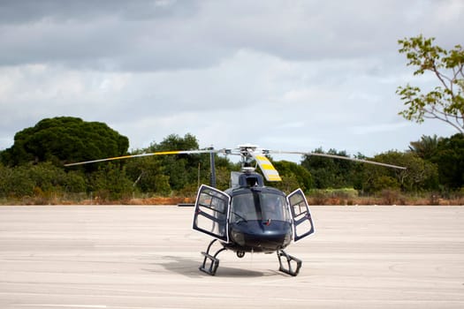 View of a small helicopter stationed on the ground.