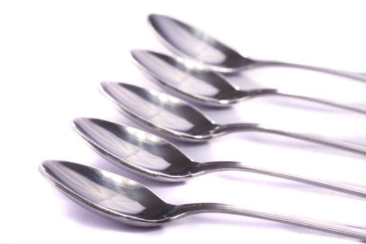 Close up view detail of some spoons isolated on a white background.