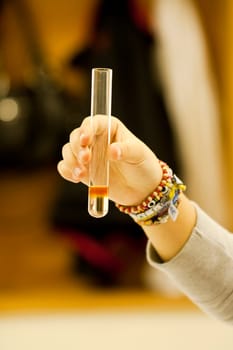 Close up view of a student of chemistry holding a test tube.