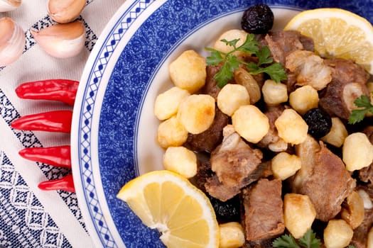 Close up view of a Portuguese meal of cooked meat with potatoes.