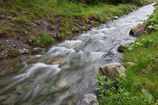 a small mountain river flowing among stones