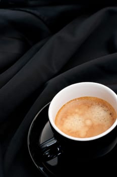 Cup of Espresso Coffee on Black Silky Drapery