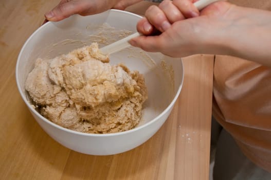 Yeast dough is stirred with a mixing spoon
