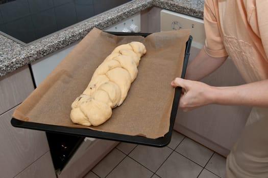 Raw yeast braid is pushed into the oven