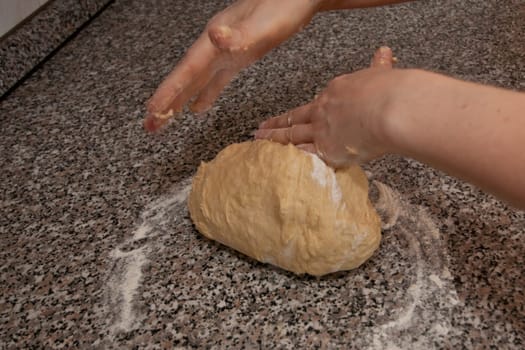 Two hands kneading a yeast dough