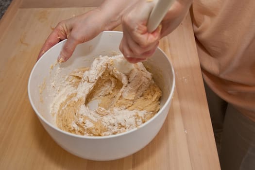 Yeast dough is stirred with a mixing spoon