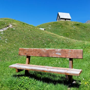chapel and bench in alpine mountain in summer