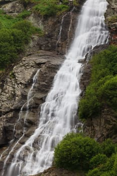 a beautiful waterfall on a mountain slope