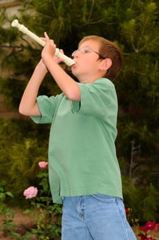 Young boy playing a recorder musical instrument