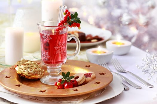 Hot wine cranberry punch for winter and Christmas and Christmas tree in background