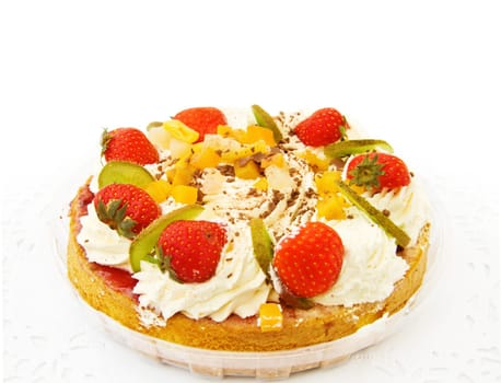 Fresh strawberry and tropical fruits cake. Isolated on white background.