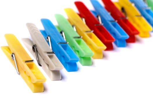 Close up view of some colorful cloth pegs isolated on a white background.