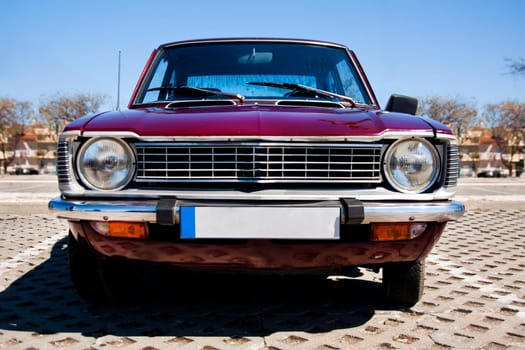 Close view of a classic car from the seventies parked on a park.