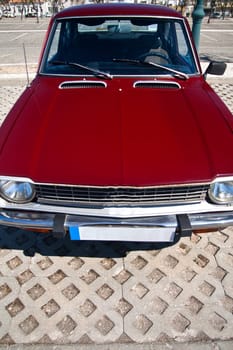 Close view of a classic car from the seventies parked on a park.