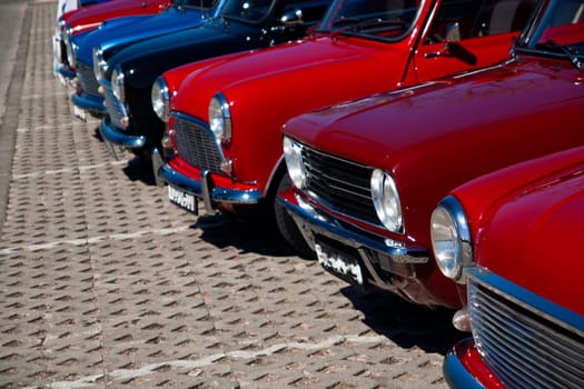 View of several mini classic cars aligned on a row.